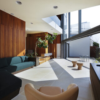 Sさんが選んだソファーが、この家のベストポジションに鎮座。テレビ横の壁は、石板をSさんが自ら１枚１枚並べたという。
