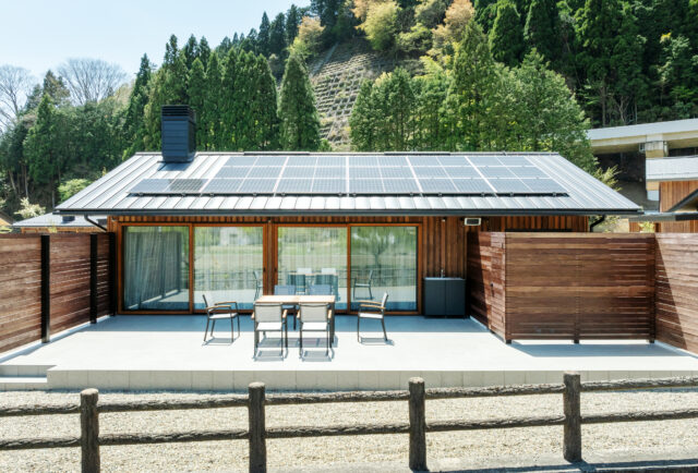 A棟テラス。リビングの大きな開口からシームレスにつながり、室内も屋外もゆったりした感覚が得られる。川が流れる音も聞こえて気持ちがいい。写真右、木材の壁で囲っているのは浴室と中庭。向かい側からの視線を気にせずに外気浴が楽しめる
