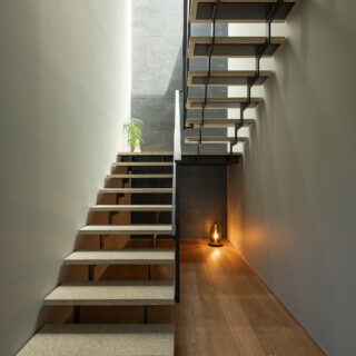 1階階段。踏板には石材を張った。２階上部にトップライトを計画。家の奥に当たる部分だが十分明るい