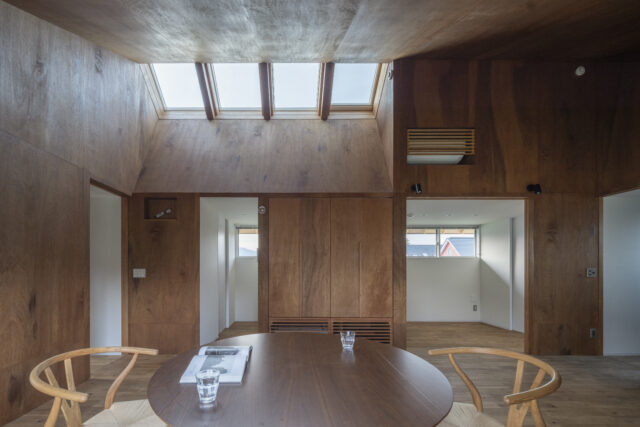明るい天窓や最大約4mの高さがある勾配天井が開放感を演出。内装も工夫し、ダイニングは木、周囲の空間は白壁と、内装カラーにメリハリをつけて奥行きを強調した。さらには全ての方角に窓を設けて視線の抜けを確保。多層的な工夫により「広く感じる空間」を実現している