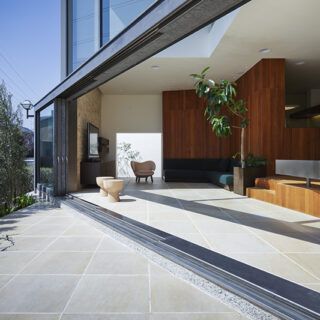 大窓は、川に正対せず斜めに配置することで桜を正面に捉える。室内であるＬＤＫとその先のガーデンの高さを揃え、内外の空間が一体となって感じらえるデザイン。さらに遊歩道を歩く人の視線を逸らす。目隠しとして遊歩道沿いにレモンやオリーブなど収穫できる樹木を植え、成長や収穫を楽しめる工夫も
