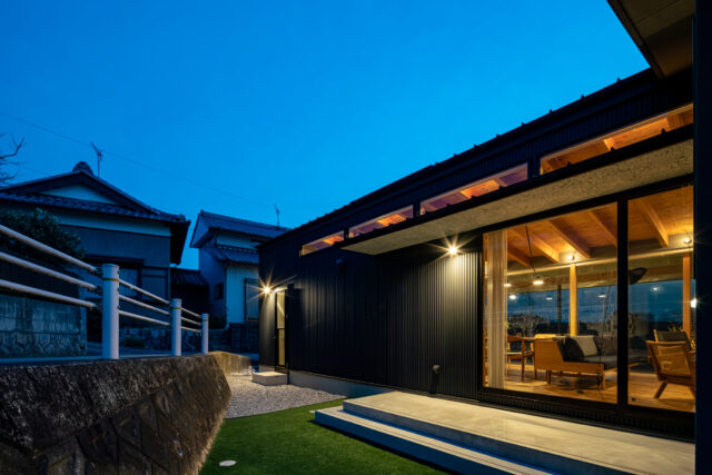 東側のプライベートガーデン。家と坂道に囲われ、子供が安全に遊ぶことができる。不整形の土地で出来てしまったスペースを有効に活用した。家屋の窓はすべて透明で、すりガラスはない。開放感を得るためだ。このスペースからも、リビング越しに西側の風景まで眺めることができる