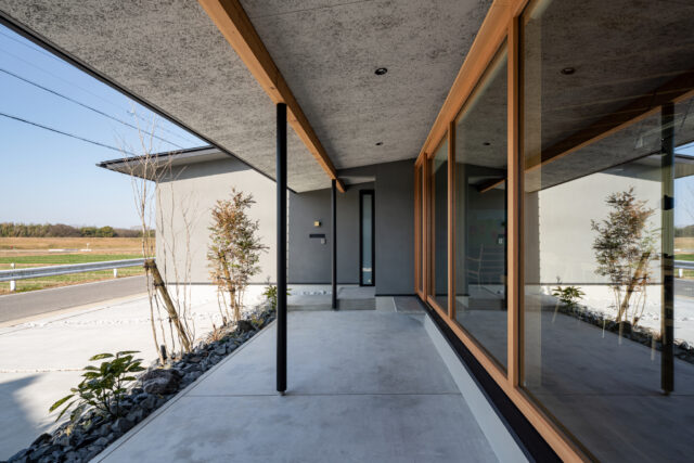 深い庇を持つデッキ。キャンプギアを試したり、ティータイムを楽しむことができる。家の外と中を穏やかに繋ぐ、中間エリアとしても機能している。庇の先に樋を設置せず、雨の日には滴り落ちる水の流れを楽しむ趣向も凝らしている