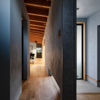 玄関ホール側から見た廊下。天井はなく、吹き抜けとしたことで空間の広がりを感じられる