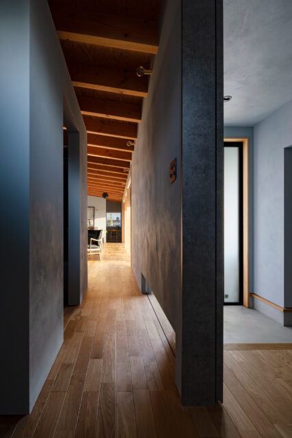 玄関ホール側から見た廊下。天井はなく、吹き抜けとしたことで空間の広がりを感じられる