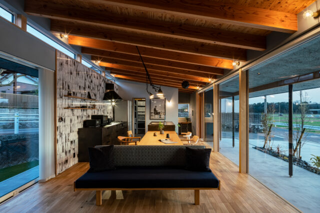 明るく開放感のあるLDK。奥行きの長さを感じられるプランだ。キッチンはII型。田園風景を眺めながら料理ができる。梁と天井は木材のあらわしで、ヴィンテージの貴重なソファなどが似合うインテリアとした