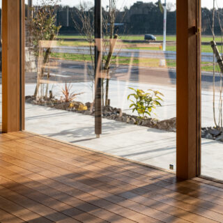 西日対策で植えられた植栽。冬以外の時期には葉が茂り、強い日差しを遮ってくれる。柔らかな樹木の影が作り出す陰影も美しい。西側のほぼすべてを開口部としたため、窓は特注で幅広の木製サッシを採用した