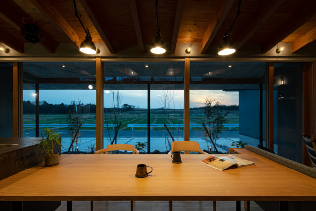 ダイニングから見た田園風景。法規制のおかげで、この先に家が立つことは長期間ないことが予測される。この風景をLDKのどこからでも満喫できるよう、開口部を最大限に広げて確保。照明もすべて、同時に手がけた