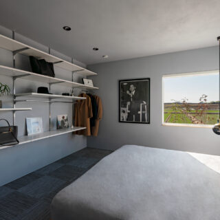 寝室。こちらの窓からも田園風景を楽しむことができる。オバマ大統領が座るポスターに映っている椅子を、お施主様は所有しているそうだ。棚は収納用ではなく、ディスプレイ用。厳選されたものが飾られている