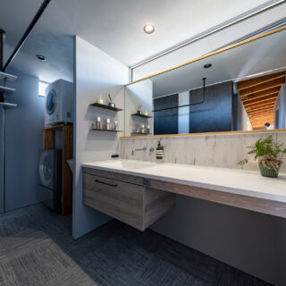 水回り。洗面台は広さを重視し、効率的な家事動線にも気を配った。奥の洗濯機・乾燥機と洗面台の間には、スロップシンクも設置されている。北側に位置するが、洗面台の幅と同じ長さのハイサイドライトにより、十分な明るさを確保している