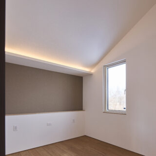 勾配天井が開放感を、コーブ照明がリラックスできる雰囲気を演出。夏はこの寝室に設置したエアコン1台だけで家全体をしっかりと冷房できるよう、温熱環境を設計した