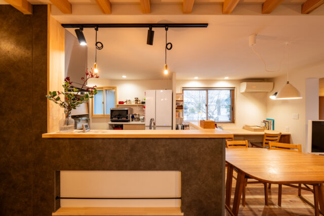 キッチン（左）、ダイニング（右）。キッチンは日々の暮らしからだんだん生活感がでてくることで、かえって魅力が増す佇まい。右の窓は以前片開きで、活用しきれていない印象だったが、現在は隣接する庭の緑が眺められる、生活を豊かにする窓に生まれ変わった