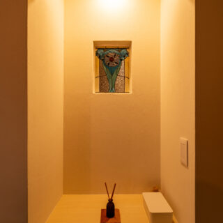 玄関からもLDKからも見える位置に奥さまのステンドグラスを取り入れた。LDK側の下部は収納棚