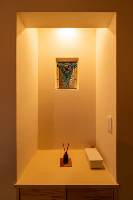 玄関からもLDKからも見える位置に奥さまのステンドグラスを取り入れた。LDK側の下部は収納棚