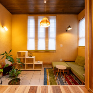 ヌック。以前は右半分がスキップフロアになっていたが、活用されていなかったため取り払った。天井が他の部分より高く、また床が低いおかげで、意識的に他のエリアと少し切り離されて感じられ、繋がっていながらも個室感ある場所となった。右のソファは以前リビングにあったもの