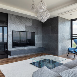 書斎とリビングを分ける壁は新たに施工し、その中にテレビを埋め込み配線などを隠蔽した。表面にはわずか1.5㎜の厚さの石を貼ることで、自然な風合を表現。