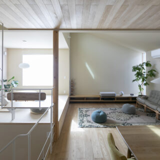 ダイニングからリビングを見る。リビングにはソファスペースと小上がりがあり、小上がりでは子どもが床座でおもちゃ遊びなどを楽しめる。一方のソファスペースは大人が落ち着ける雰囲気。写真正面の壁には、プロジェクターで映画などを映すこともできる