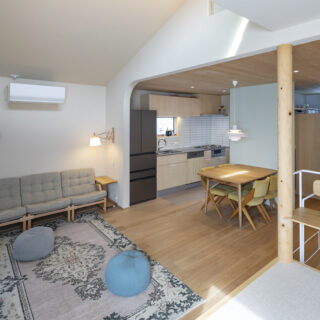 2階LDK。北側（写真右）がキッチン・ダイニング、南側（写真左）がリビングで、下がり壁や丸柱でそれとなくゾーニングされている。壁は空間ごとにアクセントカラーをプラス。ダイニングはグリーンだがとても淡い色調で、ナチュラルな雰囲気を損なわずに明るさ・楽しさを演出