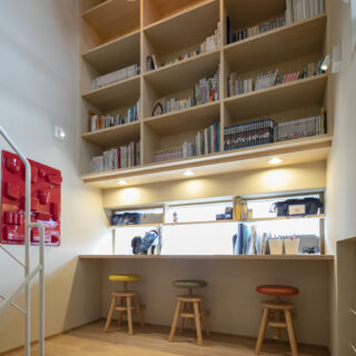 階段の踊り場に、出窓の奥行きを生かしたカウンターデスクを造作。子ども3人が並んで勉強できる