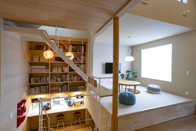 小上がりの一角には塔屋階への階段があり（写真左奥）、その一段を延ばしたベンチも居場所の1つ（写真中央）。踊り場、リビング、小上がり、そして塔屋階への階段と、空間の縦軸を上手に使ってさまざまな居場所を創出し、ほどよい距離感でゆるやかにつなげている