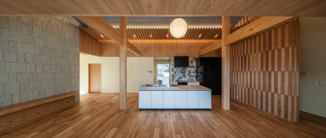 庭側から見たLDK。右側の壁は、檜と杉の大和張り。木材の美しさと陰影を楽しむことができる。左側の壁は十和田石の乱張り。柔らかい木材と硬い石材の対比を楽しむために採用した