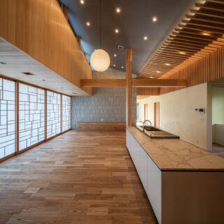 LDKは吹き抜けだが、天井は斜め勾配とし、庭側は一部低くした。面積が広いLDKなので、すべての天井を水平にすると空間が大きすぎて落ち着かなくなる。快適に生活できるよう、適度に空間の大きさをコントロール。照明はダウンライトと間接照明のみ。夜間の落ち着きを重視した