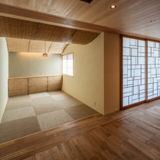 LDKに接した和室。お施主様から自由にやってほしいと言われ、曲線を多用した遊び心ある空間に。天井と奥の腰壁に葦を使用し、柔らかな空間とした。庭側の障子を和室の前まで動かし、閉ざすこともできる