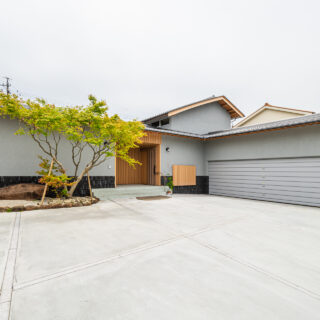 玄関前。車が3台入る車庫へスムーズに駐車できるよう、車の向きを変えるためのスペースを十分に確保した。ここから見えるむくり屋根の曲線も美しい