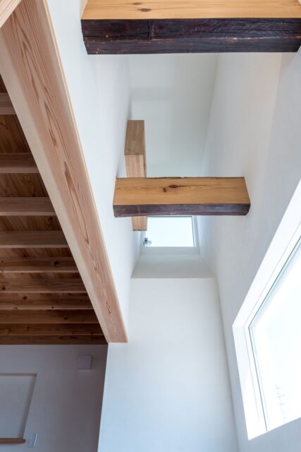 冷気で暖気を押し上げる重力換気を採用。玄関の通風窓から空気を取り入れ、2階の高窓から外へ排出。仕切りのない空間設計と効果的な窓の配置により、機械に頼らない自然な換気を実現した