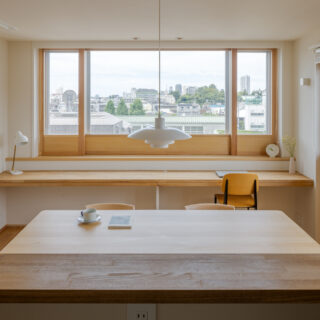 3方の窓に造作内窓を設置、景色を切り取り、視界に余計なものを入れない。西側には広いデスクを造り付けて、夫婦で利用できるワークスペースを生んだ。またハニカムスクリーンも設置され、さらなる断熱効果や西日対策に。