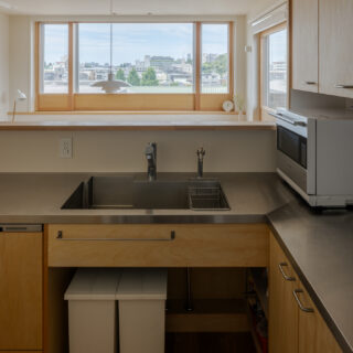 オープンなキッチンとしたことで、作業をしながら遠くの景色を楽しめる。回遊動線で使い勝手も良い。キッチンはIHや食洗器を仕込んだ造作のオリジナル。手元の雑然としたものをダイニングに見せないよう、カウンターを立ち上げている。