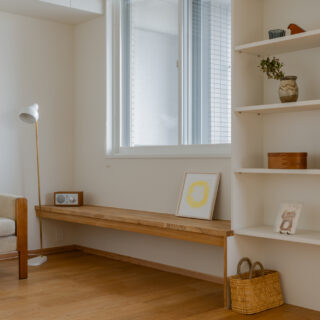 リビングには、飾り棚兼ベンチや、息子さんが選んだ椅子も。本棚には美術書が置かれ、読書コーナーにもなるほか、ディスプレイとしても活用されている。