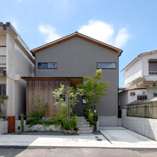 切妻屋根にグレーの塗り壁の落ち着いた佇まいの邸宅。壁の一部が杉になっているのは、「ツートンカラーにしたい」というYさんのリクエストに対して素材そのものを変えるという夛田さんのアイデア。杉の風合いの変化が、この家とともに歩む歴史を刻んでいく。