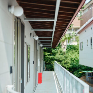 共用通路。雨天時にうれしい深い庇は上部の鉄骨で支えている。おかげで柱を立てずに済み、通路はすっきり