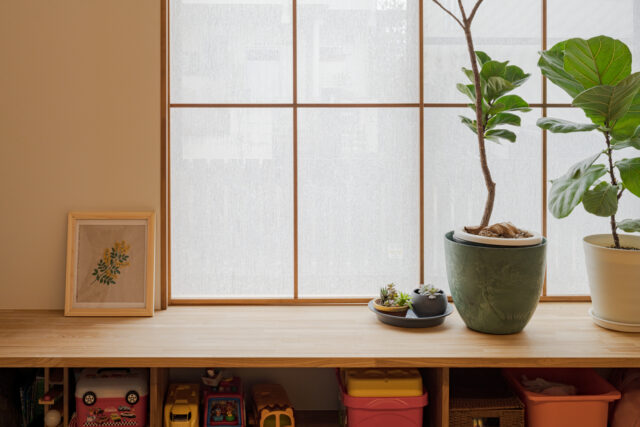 リビングの窓辺にはベンチを設置。庭の景色を見ながらのんびりしたり、太陽の温もりを感じながら読書したり。棚としての利用やお子さんの遊び場やおもちゃ収納にもなっている。