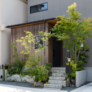 道路側からの視線を避けるため、基礎を立ち上げた。自然の風合いをもつ大谷石の階段を上り、邸内に入る。