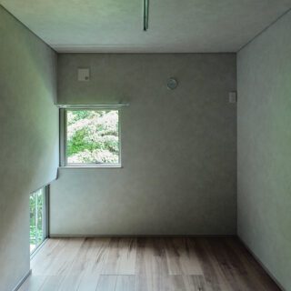 森に面した森棟、庭棟の個室には緑を眺められる窓が複数ある。写真左下はインナーバルコニーに面した地窓。立っているとき、座っているときで森の見え方が変わり、室内で過ごす時間がいっそう楽しくなる