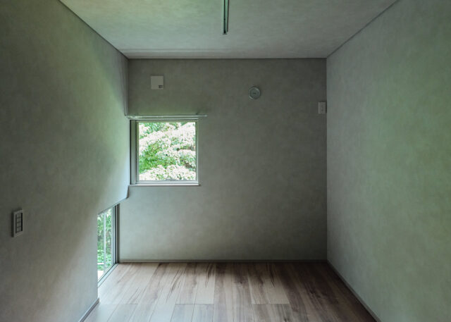 森に面した森棟、庭棟の個室には緑を眺められる窓が複数ある。写真左下はインナーバルコニーに面した地窓。立っているとき、座っているときで森の見え方が変わり、室内で過ごす時間がいっそう楽しくなる