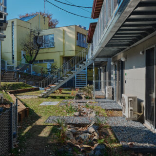 写真手前から庭棟、森棟。この2つの棟の1階住戸の前にはレインガーデンがつくられている。斜面の上から流れてくる雨水はここに貯留されてゆっくり土に浸透し、オーバーフローした分が下の森に流れるという仕組み。豪雨など急な増水の際、住宅浸水を防ぐのに役立つ