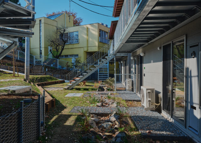 写真手前から庭棟、森棟。この2つの棟の1階住戸の前にはレインガーデンがつくられている。斜面の上から流れてくる雨水はここに貯留されてゆっくり土に浸透し、オーバーフローした分が下の森に流れるという仕組み。豪雨など急な増水の際、住宅浸水を防ぐのに役立つ