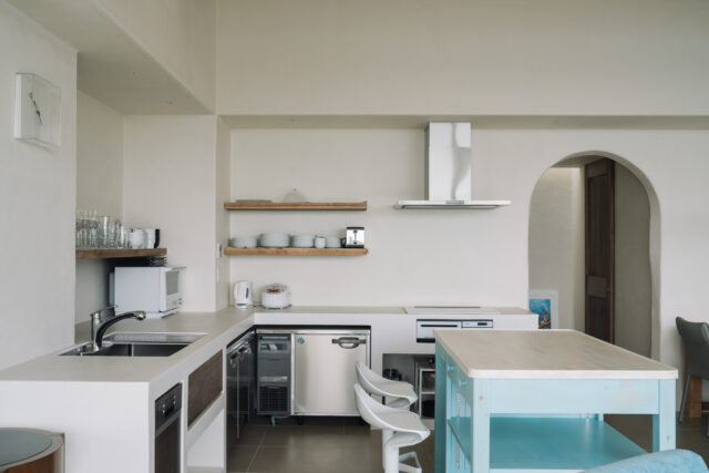 料理をしながらみんなで楽しさを共有できるよう、LDKの一角に設けられたキッチン。コンクリートで造作したオリジナルで、キッチンカウンターだけは汚れが付きにくいよう、漆喰ではなくツルッとした質感の塗り仕上げを採用。小さな作業台も家具職人につくってもらったオリジナルだ