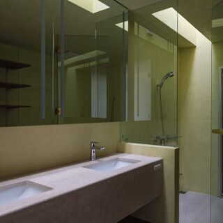 ベッド裏側の洗面脱衣所と浴室。浴室にはトップライトを設けた。浴室の奥がサウナとなっている