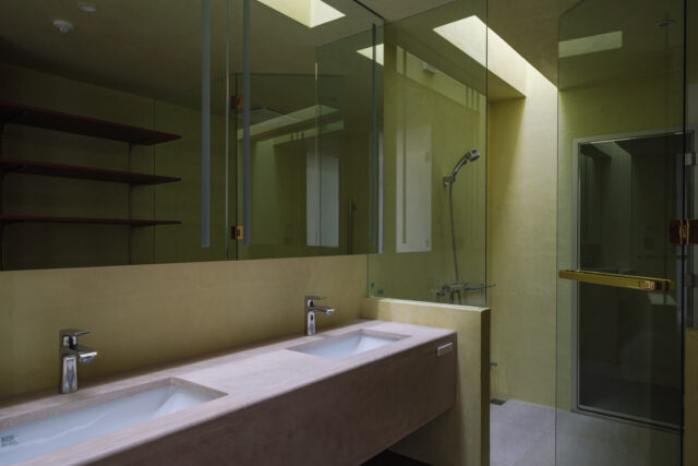 ベッド裏側の洗面脱衣所と浴室。浴室にはトップライトを設けた。浴室の奥がサウナとなっている