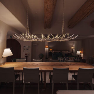 キッチン側からリビングダイニングを見る。シャンデリアとアンティークのスタンドライトのやわらかい光が部屋を優しく包む。補助的にダウンライトも設けられている