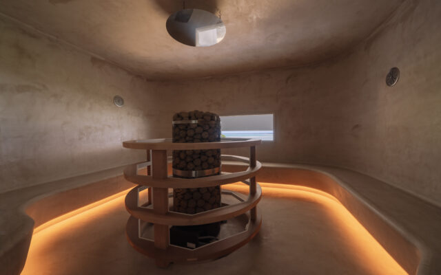 1階に設けられたドライサウナ。ベンチに腰を掛けた状態で小窓から海が眺められるよう高さが計算されている。ベンチの立ち上がりは、垂直ではなく斜めに仕上げている。ふくらはぎが直接当たらないので熱くない