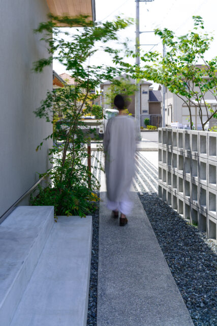 玄関と道路をつなぐアプローチ。道路側は有孔ブロックでさりげなくガードしてあり、安心感がある