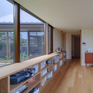 中庭を囲む空間の1つであるフリースペースは、お子さんのピアノやHさん所蔵のコミック本を置く場所が欲しいとの要望に応えてつくった。2階に子ども部屋はあるものの、お子さんたちはここで過ごすことが多いそう。中庭を挟んだはす向かいはLDKで、家族の距離感もほどよい