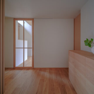 玄関ホール。LDKへのガラス戸は奥村さんのデザイン。写真右奥の戸を開けると玄関の土間収納に入れる