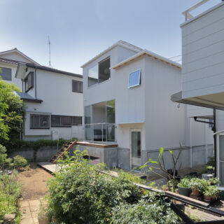 道路側の窓前には、子どもの勉強やテレワークにも使えるつくり付けのデスクを設けた。エアコンは、上部の棚とサイズを合わせてルーバーで目隠しすることで、すっきり納めている。