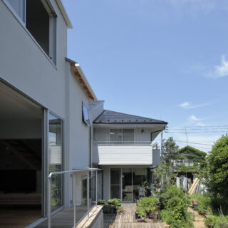 実家のウッドデッキとシームレスにつながる。子どもたちは、毎日のようにここを通って実家と行き来するのだとか。庭には様々な樹々や草花が植えられ、四季折々の楽しさのひとつになっている。